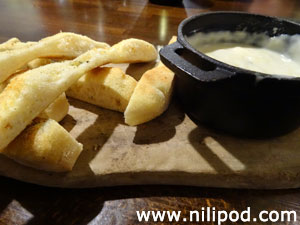 Photo of cheese fondue with slices of focaccia bread