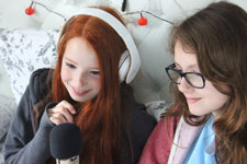 Small photo of girls laughing into microphone